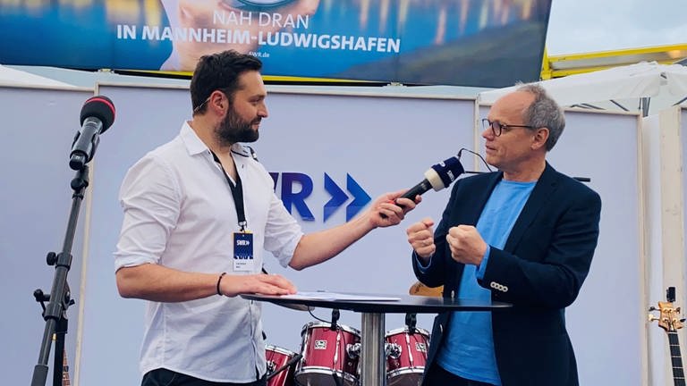 SWR Moderator Robert Wolf interviewt SWR-Intendant Kai Gniffke auf der Bühne im Gläsernen Studio auf dem Mannheimer Maimarkt