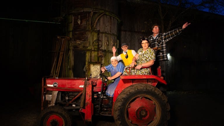 Comedy Duos Hillu's Herzdropfa (Hillu Stoll, li. und Franz Auber) und Elsbeth und Alois Gscheidle (Birgit Pfeiffer und Marcus Neuweiler, re.) sitzen auf einem roten Traktor (Foto: SWR)