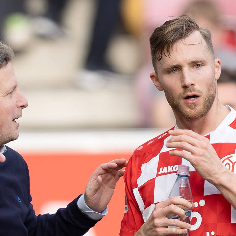 Trainer Bo Henriksen vom 1. FSV Mainz 05 gibt seinem Kapitän Silvan Widmer Anweisungen