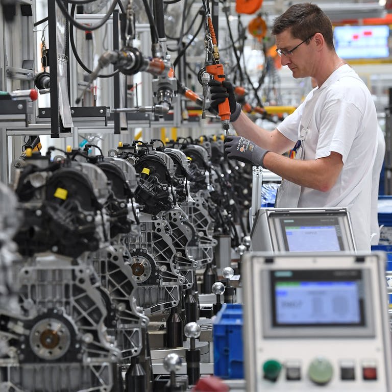 Ein Mann arbeitet in einem Motorenwerk von Volkswagen an der Fertigungslinie an Motoren.  (Foto: dpa Bildfunk, picture alliance / Hendrik Schmidt/dpa-Zentralbild/dpa | Hendrik Schmidt)