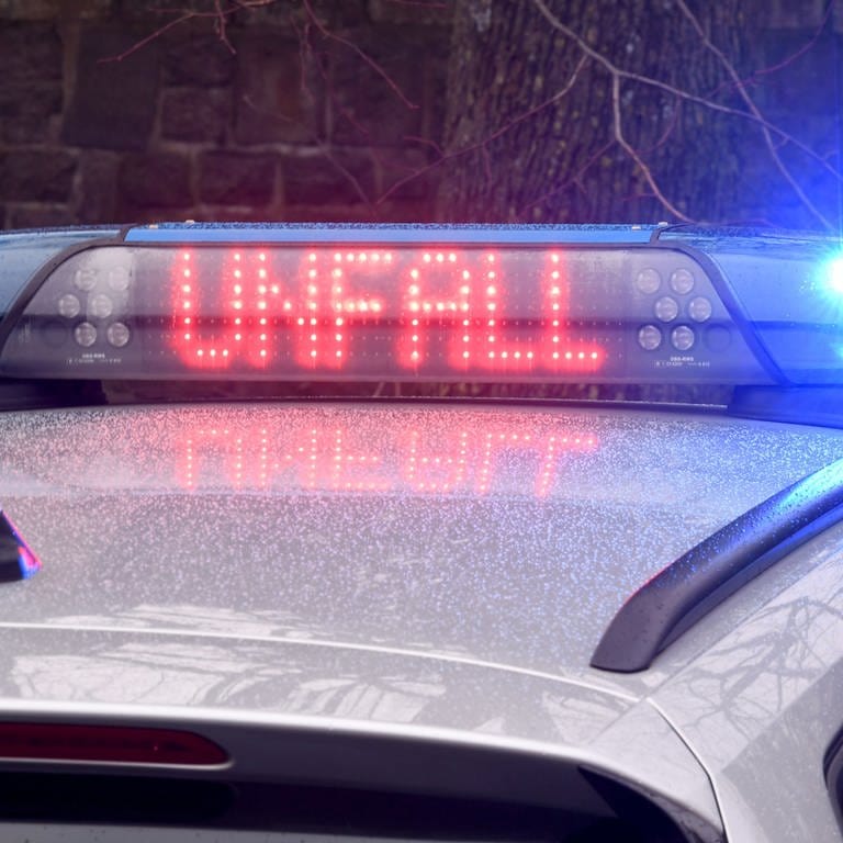 Ein Polizeiauto mit Blaulicht, auf der Anzeige steht "Unfall" (Symbolbild)