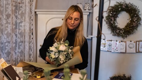 Junge Frau bindet einen Blumenstrauß in einem Blumenladen
