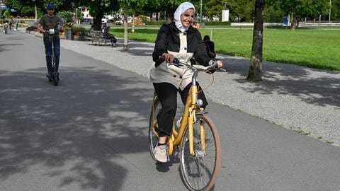 Frau mit Fahrrad und Kopftuch (Foto: IMAGO, IMAGO I Pius Koller I Bild-ID 300970293)