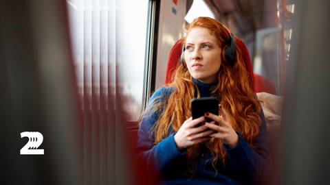 Eine Frau mit Kopfhörern während einer Bahnfahrt  (Foto: IMAGO, imago images/Image Source)