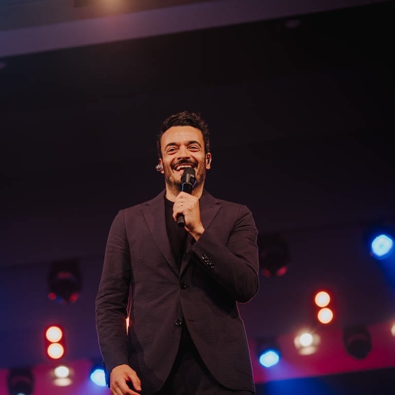 Giovanni Zarrella beim SWR4 Festival in Hüfingen steht auf der Bühne und grinst ins Publikum.