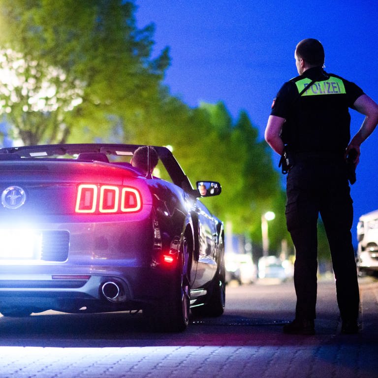 Symbolbild: Polizisten kontrollieren ein getuntes Fahrzeug am Expo-Park in Hannover (Foto: dpa Bildfunk, picture alliance/dpa | Julian Stratenschulte (Symbolbild))