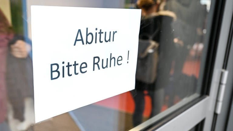An einer Tür in einem Gymnasium steht "Abitur Bitte Ruhe!" auf einem Schild.