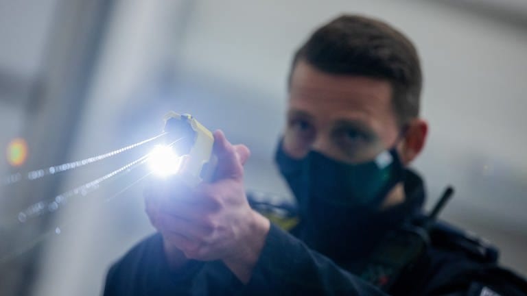 Ein Polizeibeamter demonstriert einen Schuss mit einem Distanz-Elektro-Impulsgerät (DEIG),  auch Taser genannt.