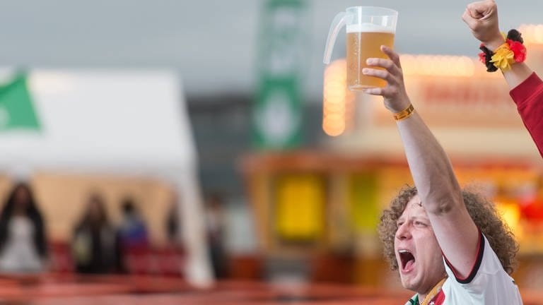 Ein Fan hält während eines EM Spiels ein Bier in der Hand und grölt.  (Foto: dpa Bildfunk,  Patrick Seeger)