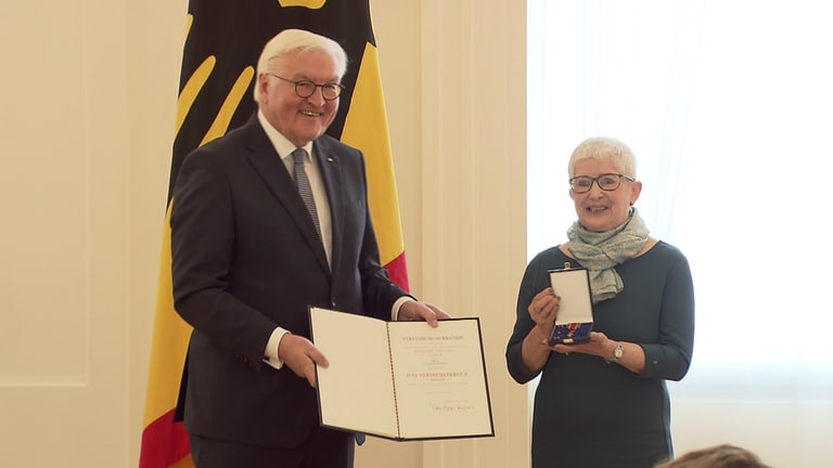 Bundespräsident Frank-Walter Steinmeier und Carola Grasse mit Bundesverdienstkreuz und Urkunde
