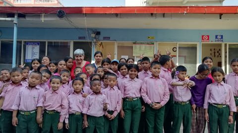 Waisenkinder in Schuluniform umringen die Gründerin des "Hauses der Hoffnung" in Kathmandu. Acht junge Menschen machen jetzt eine Ausbildung an der Stauferklinik Mutlangen