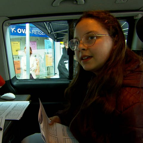 Ein Mädchen spricht beim Verkaufsoffenen Sonntag in Aalen im Reportagewagen vom SWR Haltestellen für den Stadtbus ein. 