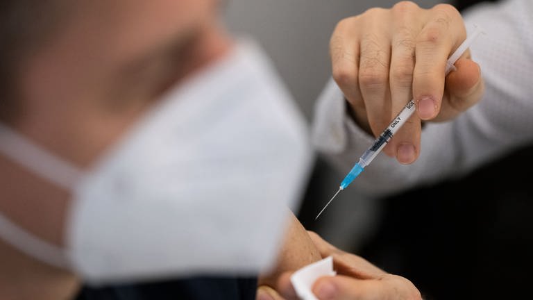 Ein Mann wird in einem Impfzentrum in der Innenstadt mit dem an die Corona-Variante Omikron BA.4-5 angepassten Comirnaty-Wirkstoff von Biontech geimpft. 