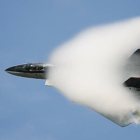 Ein Kampfjet fliegt mit Überschallgeschwindigkeit und durchbricht die Schallmauer. (Foto: picture-alliance / Reportdienste, picture alliance / Zoonar | Andrey Nyrkov)