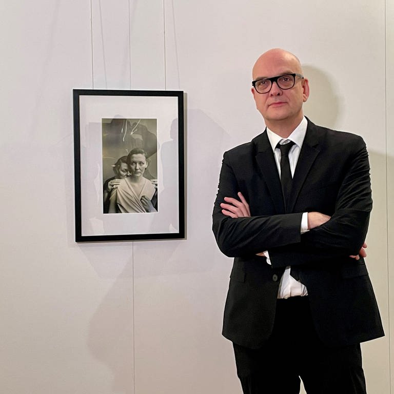 Der Fotomedia-Künstler Boris Eldagsen neben seinem Bild "Electrician", das mit Hilfe Künstlicher Intelligenz (KI) generiert wurde.