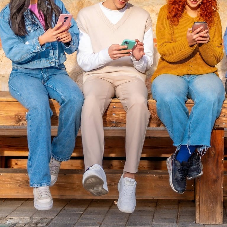 Eine Gruppe junger Menschen sitzt auf einer Bank