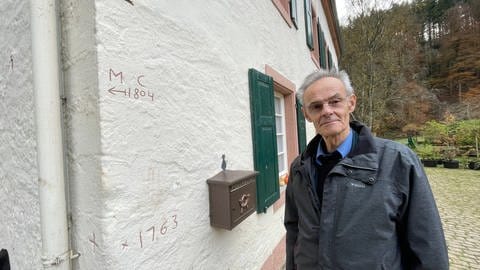Die Markierungen am Haus von Hans-Christoph Richarts zeigen, wie hoch die Kyll hier mal stand. Der 80-Jährige hat schon viele Hochwasser erlebt.  (Foto: SWR, Christian Altmayer )