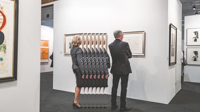 Menschen steht vor einem Bild in einer Ausstellung 