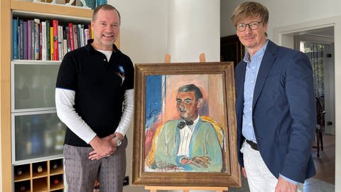 Rüdiger Schwarz und Jürgen Oßwald mit einem Gemälde von Rudolf Levy