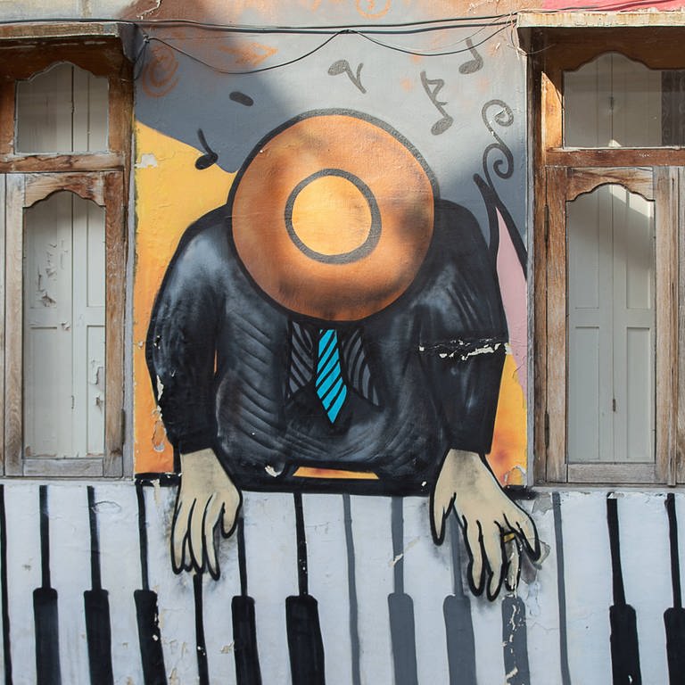 Grafitti "Piano-Spieler" an einer Hauswand in Batumi, Georgien.