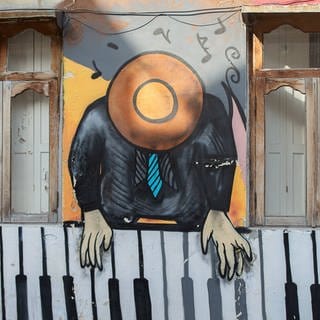 Grafitti "Piano-Spieler" an einer Hauswand in Batumi, Georgien. (Foto: IMAGO, IMAGO / Zoonar)