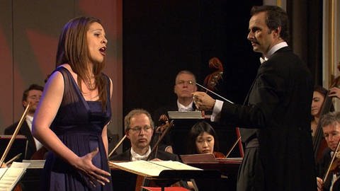 Sängerin mit Dirigent und Orchester