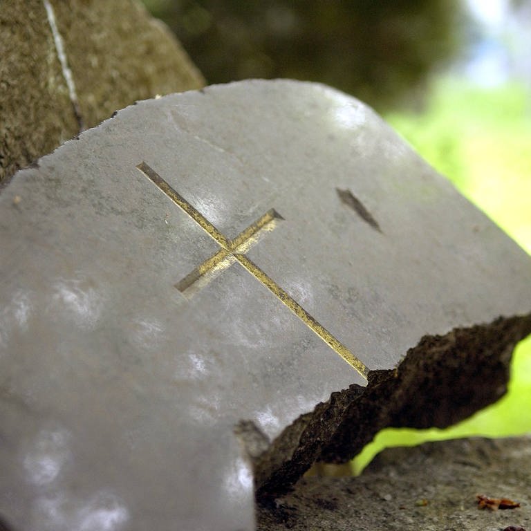 Kaputter Grabstein mit einem Kreuz (Foto: IMAGO, imago)