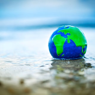 Erdkugel im Wasser, Symbolfoto fuer den Anstieg des Meeresspiegels durch den Klimawandel