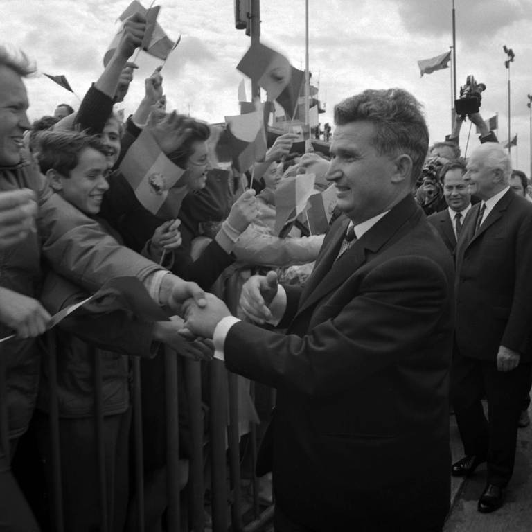 Der rumänische Staatspräsident Nicolae Ceausescu, der sich weigerte, an der Invasion der Tschechoslowakei durch Truppen des Warschauer Pakts im Jahr 1968 teilzunehmen und diese Aktion offen verurteilte, kam am 15. August 1968 zu einem Staatsbesuch nach Prag. Ceausescu wurde vom tschechoslowakischen Präsidenten Ludvik Svoboda begleitet (rechts) und schüttelt Menschen die Hand, die ihn am Flughafen begrüßten. (Foto: IMAGO, IMAGO / CTK Photo)