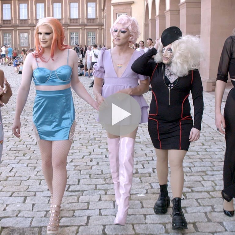 Vier Dragqueens und ein Dragking aus Mannheim laufen nebeneinander auf der Straße