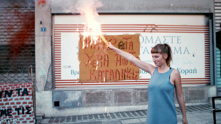 „#widerstand“: Helene zündet am Ende der Demo in Athen, gegen die geplante Räumung der besetzten Häuser, ein Bengalo an. © SWREikon Media
