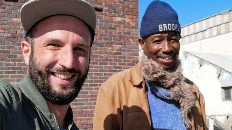 Patrick, obdachloser Chefkoch, und Regisseur Benjamin Rost schauen lächelnd in die Kamera. "Auf der Jagd nach dem Glück" von Benjamin Rost. (Foto: SWR, Benjamin Rost)