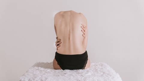 Ein Körper umarmt sich selbst: Sexologinnen und Sexualtherapeuten sind der Ansicht, dass mehr Fühlen, Spüren und Berühren heute ein Schlüssel dafür sein können, um zur eigenen Liebesfähigkeit und zum „guten Sex“ zu finden (Foto: IMAGO, IMAGO / Cavan Images)