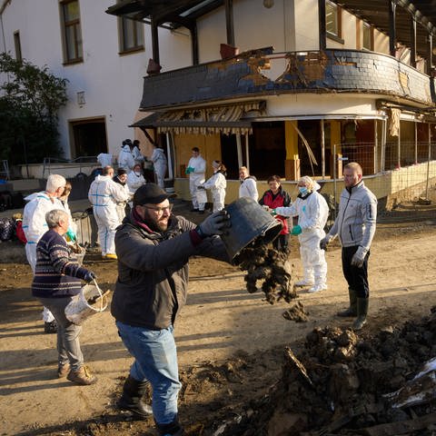 Helfer befördern Schlamm aus einem Haus in Altenahr im Ahrtal nach der Flutkatastrophe  (Foto: picture-alliance / Reportdienste, picture alliance/dpa | Thomas Frey)