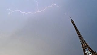 Ein Blitz ist direkt über dem Pariser Eiffelturm am Himmel zu sehen.