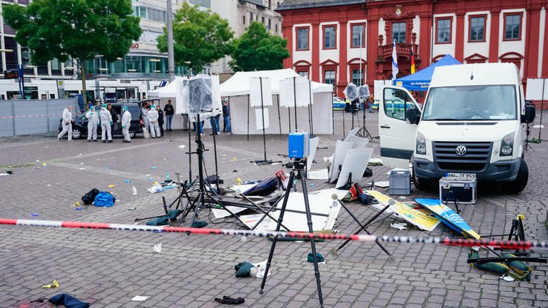 Spurensicherung steht auf dem Marktplatz hinter einem zerstörten Stand in Mannheim