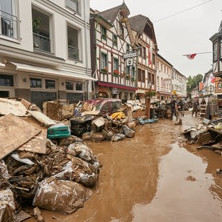 Anwohner und Ladeninhaber in Bad Neuenahr-Ahrweiler befreien ihre Häuser vom Schlamm und bringen unbrauchbares Mobiliar nach draußen. Die Versicherungen haben mittlerweile viele Schäden beglichen. 