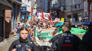 Demonstranten und Polizisten zwischen Marburger Fachwerkhäusern