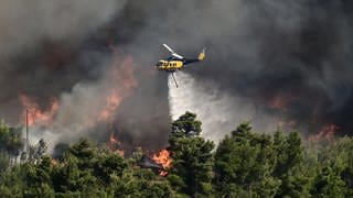 Ein Helikopter bekämpft ein Feuer in Griechenland