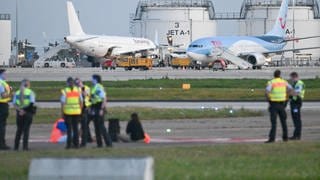 Polizisten sind wegen einer Protestaktion der "Letzten Generation" auf dem Flughafen in Stuttgart im Einsatz.