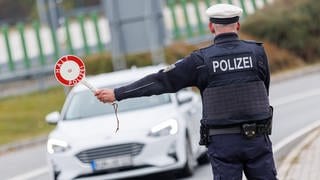 Ein Beamter der Bundespolizei stoppt bei der Kontrolle des Einreiseverkehrs am deutsch-tschechischen Grenzübergang den Fahrer eines Autos bei der Einreise. 