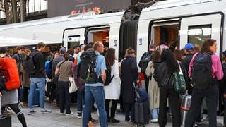 Reisende steigen in einem Zug der Deutschen Bahn.