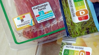 Auf Lebensmittelpackungen stehen Kennzeichnungen über Tierwohl, Haltungsform und Nutriscore.