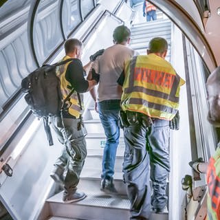 Polizeibeamte begleiten einen Mann bei einer Abschiebung in ein Flugzeug. (Archivbild: 30.07.2019)