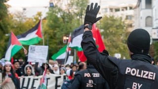 Ein Polizist stopppt eine pro-palästinensische Demonstration in Bayern.