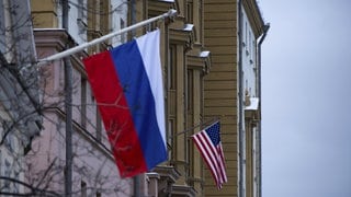 Die US-Flagge weht am Gebäude der US-Botschaft in Moskau, im Vordergrund ist die russische Flagge zu sehen.