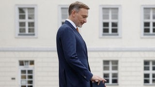 Christian Lindner vor dem Schloss Bellevue, in der rechten Hand mit spitzen Fingern eine Entlassungsurkunde