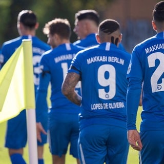 Archivbild: Spieler von Makkabi Berlin betreten vor dem Anpfiff das Spielfeld und tragen Armbinden aus schwarzem Stoff. (Quelle: dpaSkolimowska)