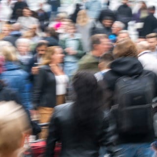 Passanten laufen durch eine Fußgängerzone in München.