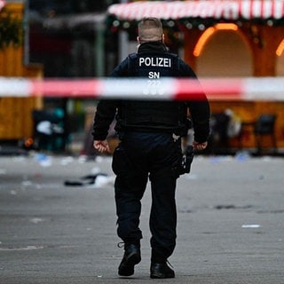 Polizist geht in Magdeburg, Ostdeutschland, über einen leeren und abgesperrten Weihnachtsmarkt.